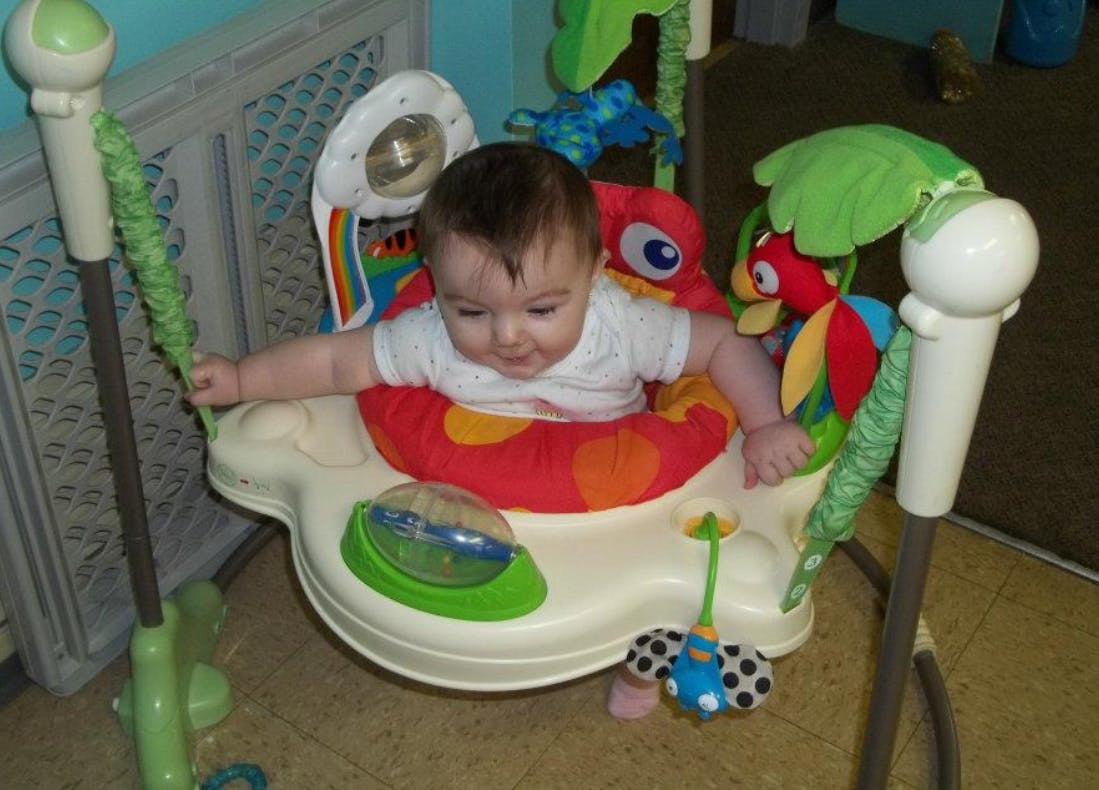 Child in a baby bouncer with toys
