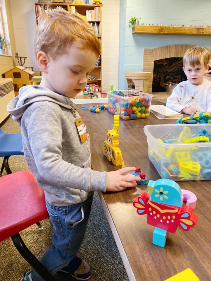 Child playing with colorful blocks at a table