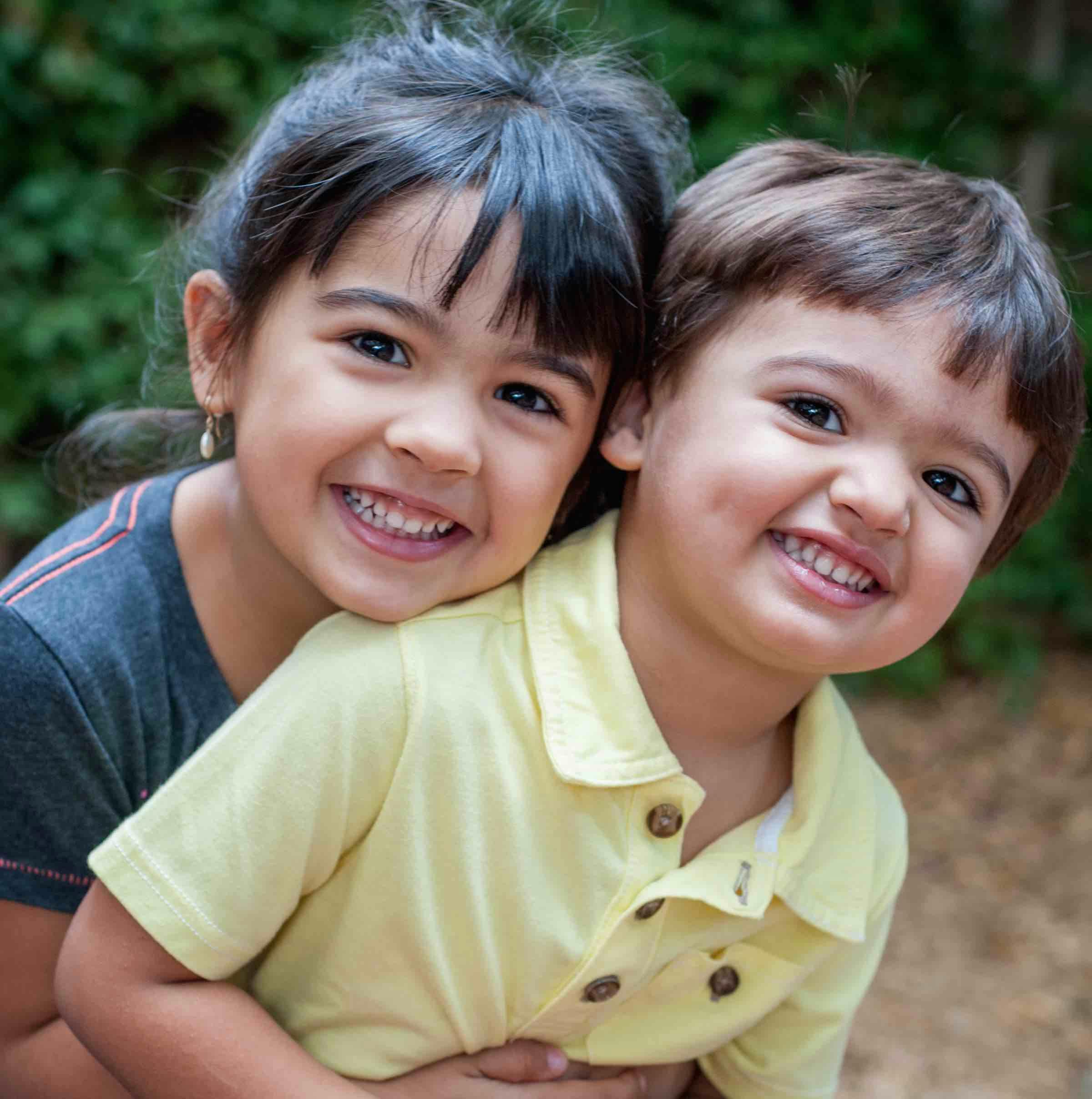 Child hugging another child from behind