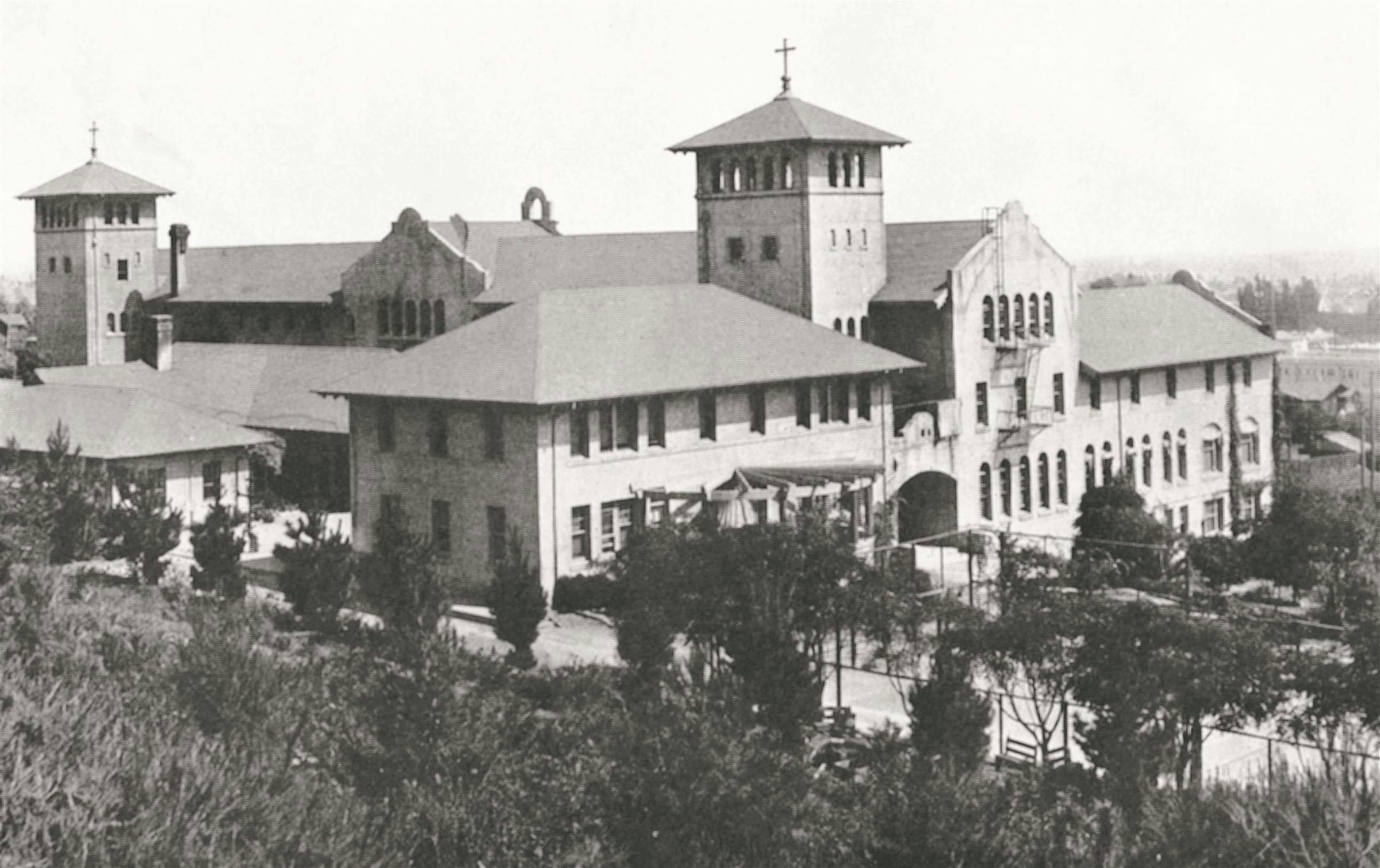 Large institutional building with towers and cross atop one roof