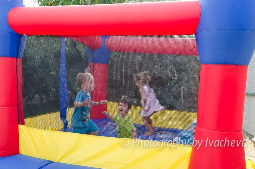 Three children playing in an inflatable bounce house
