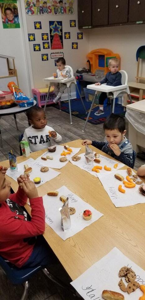 Children sitting at tables with snacks