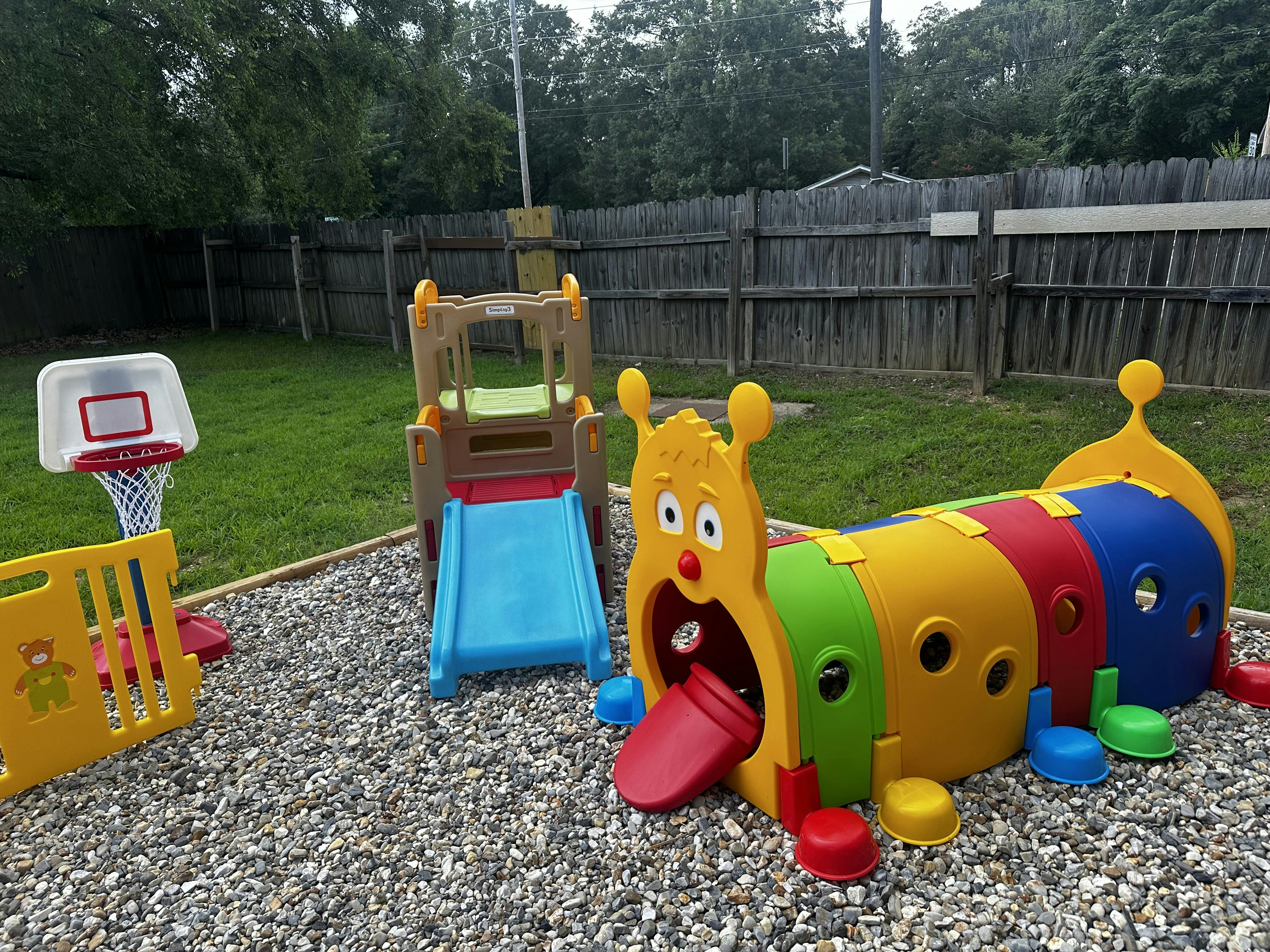 Playground with a slide, basketball hoop, and caterpillar tunnel