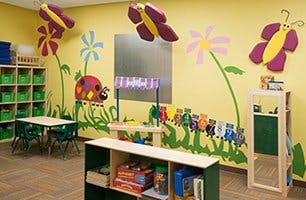 Children's classroom with colorful wall decorations and small tables