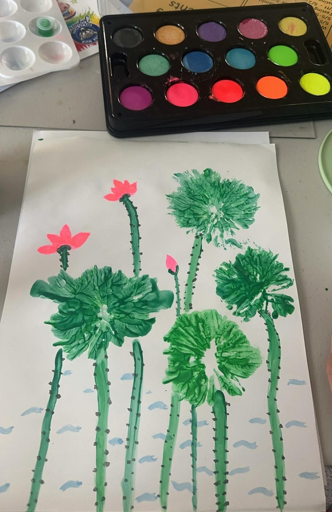 A painting of lotus plants with green leaves, pink flowers, and stems, with paint palette