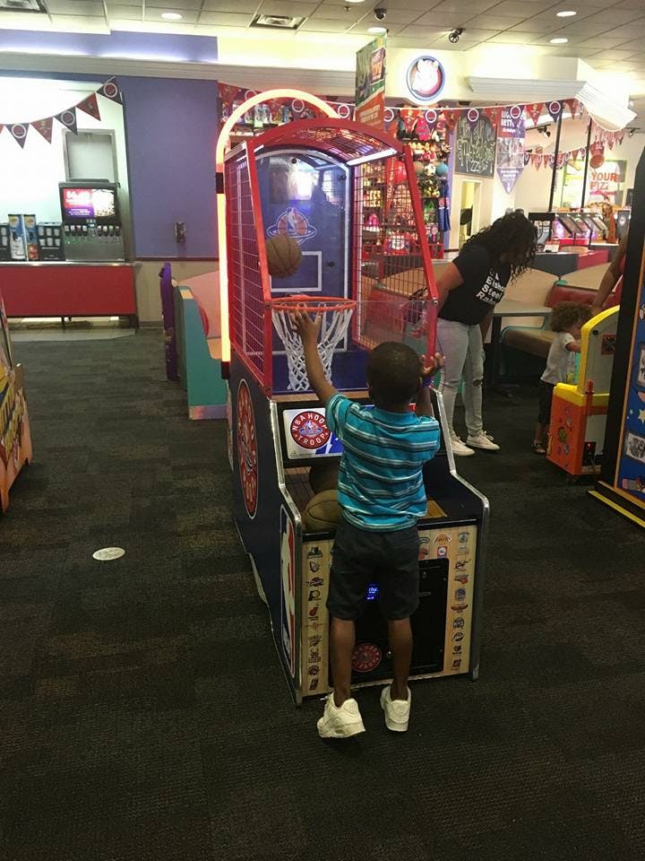 Child playing a basketball arcade game