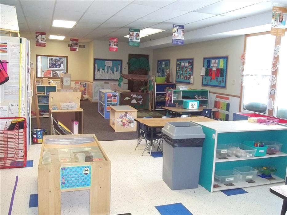 An empty classroom with desks, shelves, and various learning stations