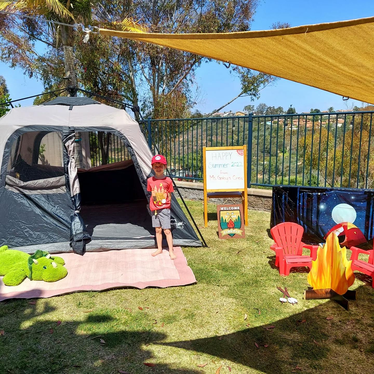 Child standing outside a tent with camping decorations