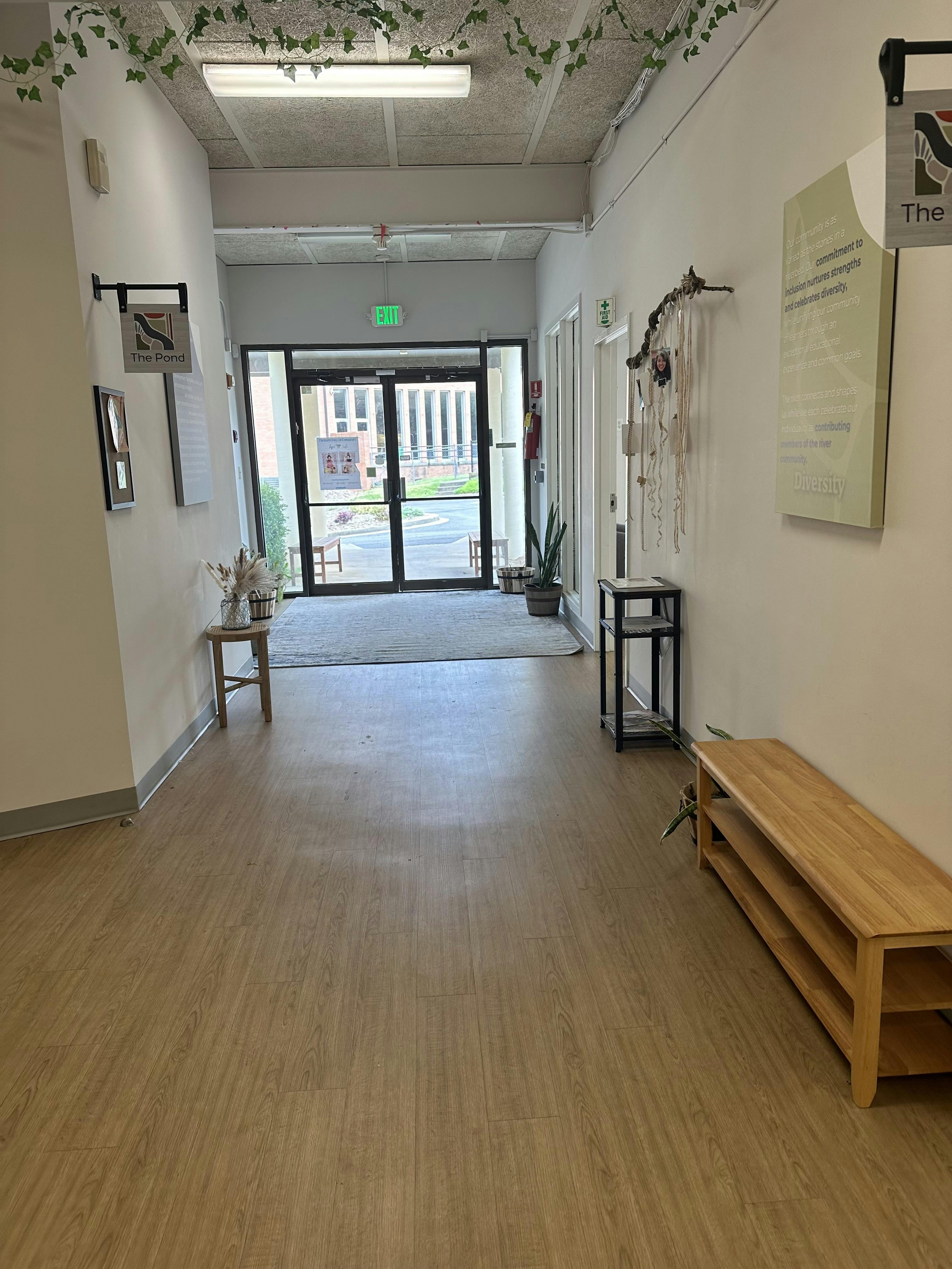 Hallway leading to glass doors with an exit sign overhead