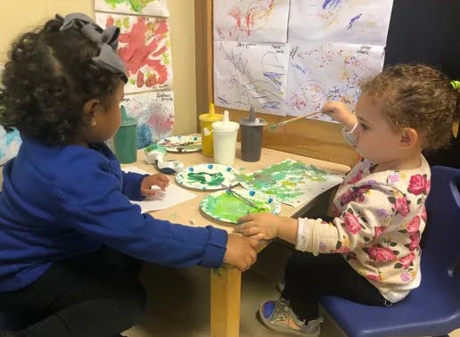 Two children painting at a table