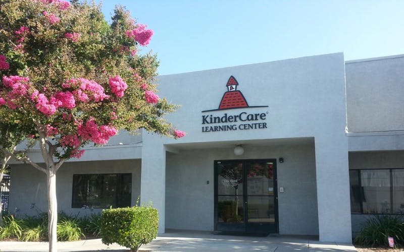 KinderCare Learning Center building exterior with a pink flowering tree