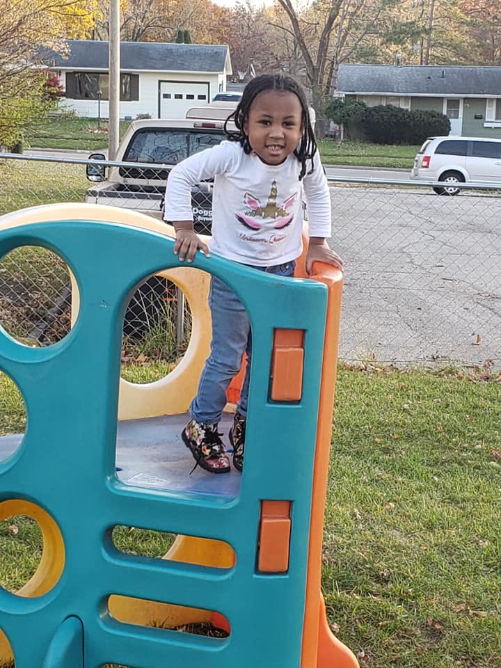 Child standing on a colorful plastic play structure