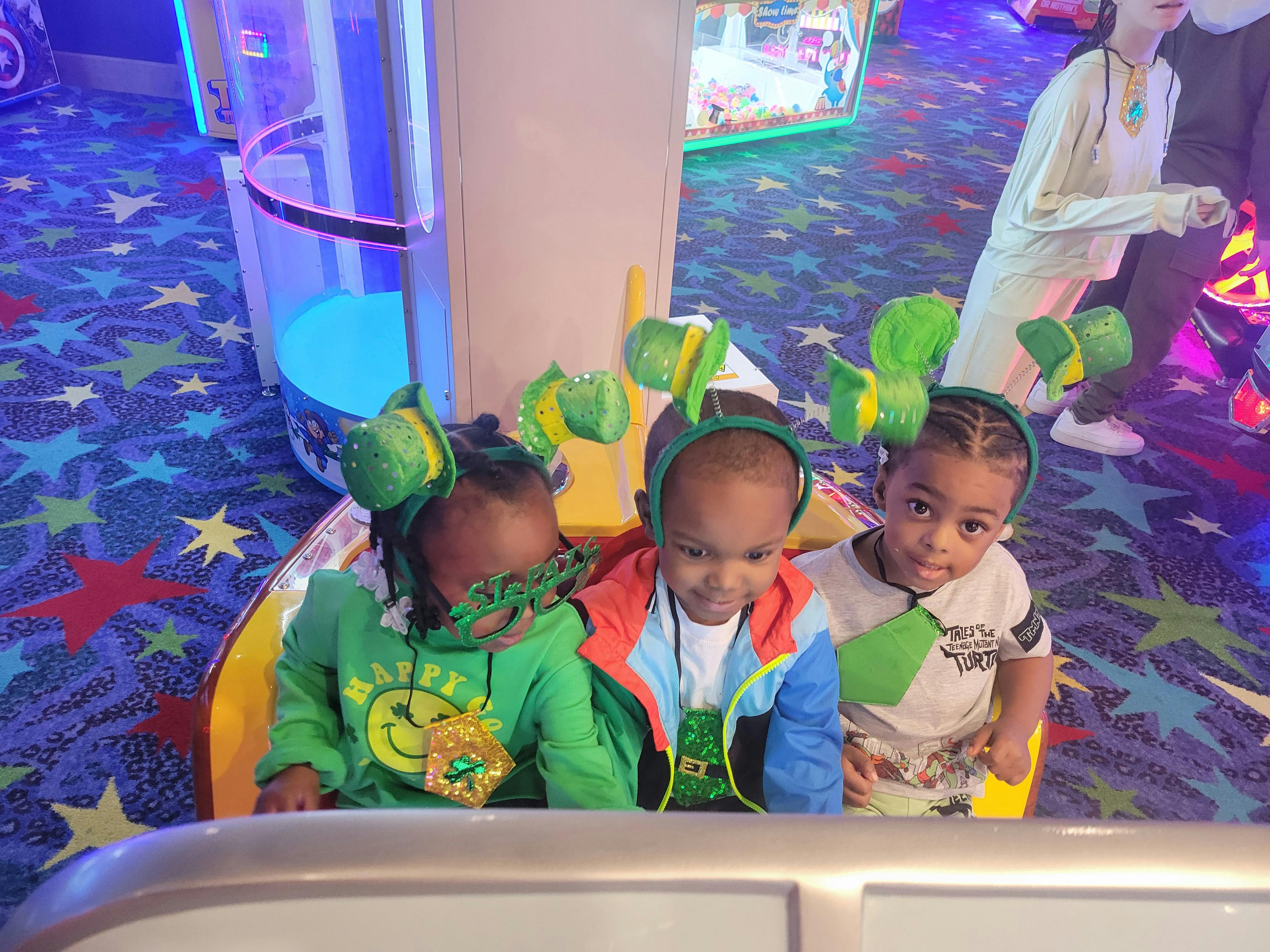 Three children wearing green headbands and glasses