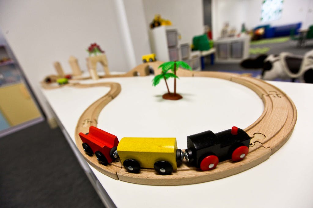Toy train on a wooden track with a small palm tree