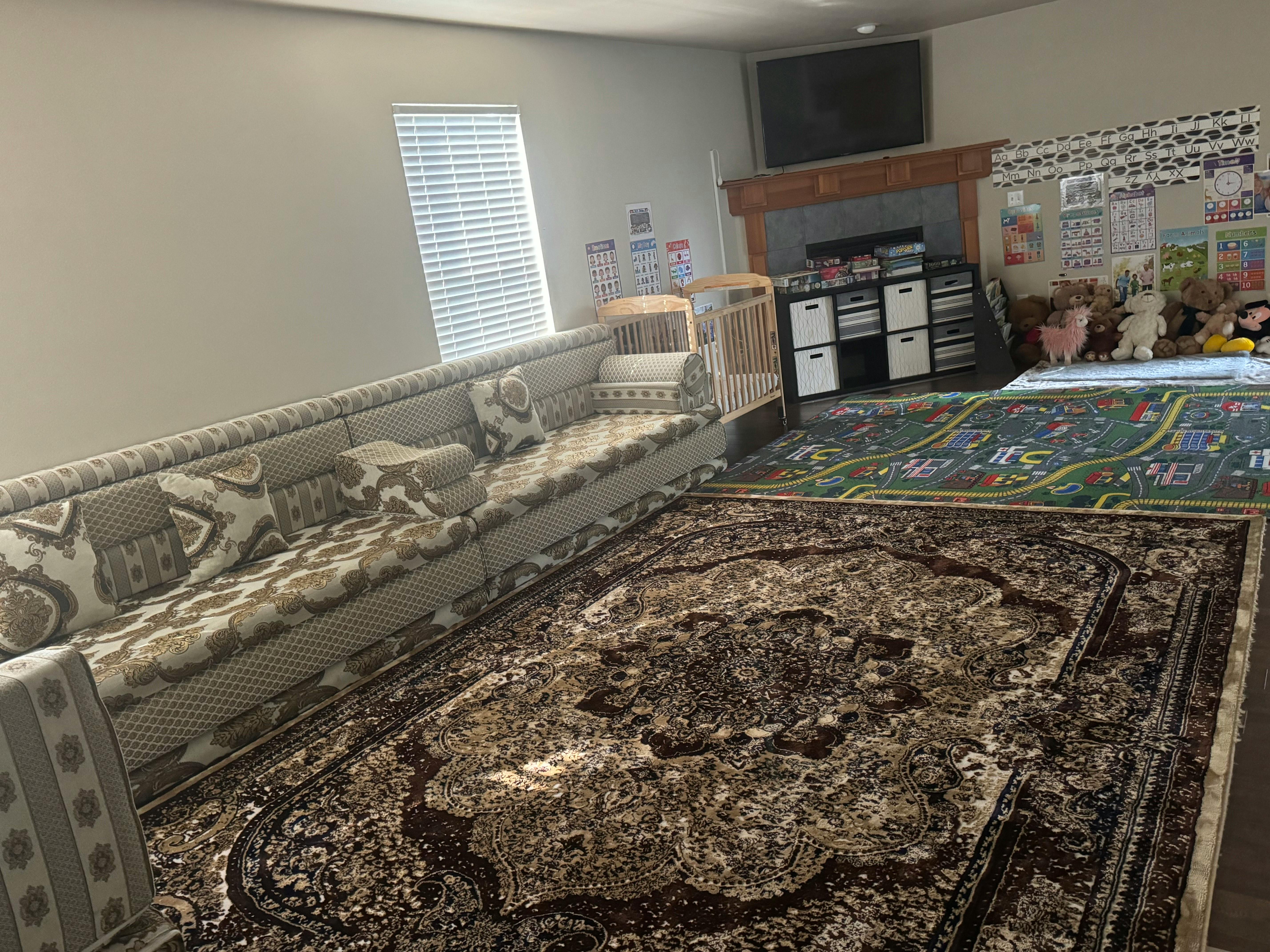 Living room with patterned rugs and a long sofa against a wall