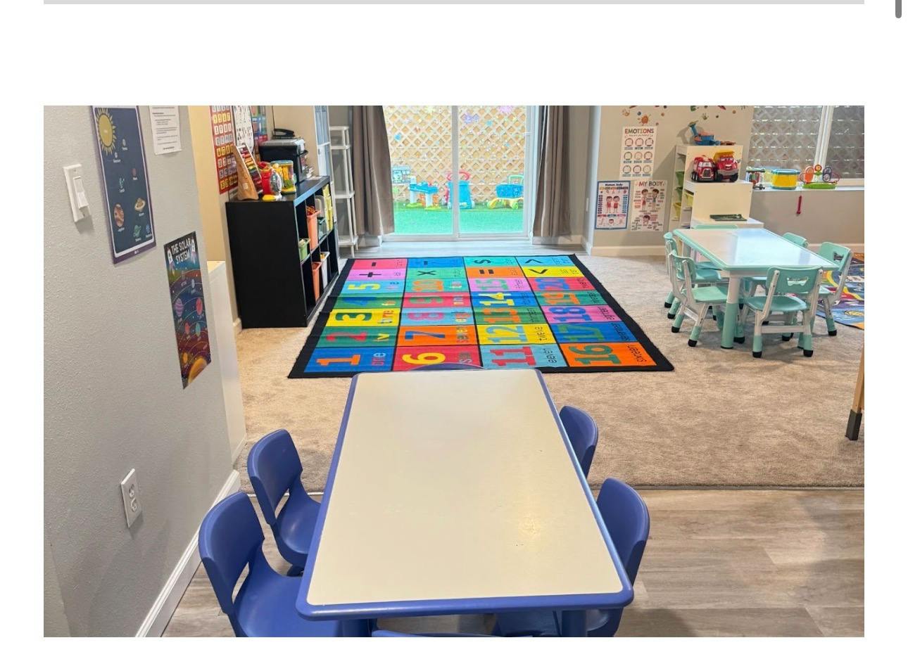 Classroom with small tables, chairs, and a numbered educational floor mat