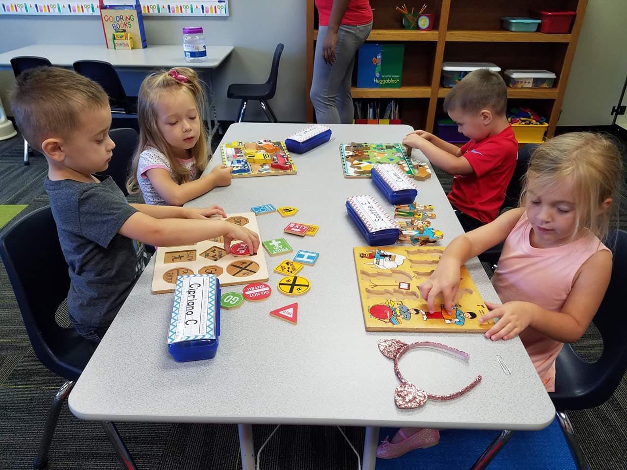 Four children playing with puzzles at a table