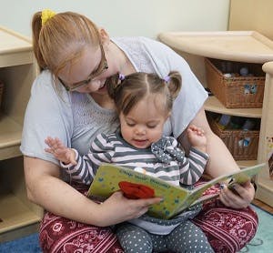 Adult and child reading a book together