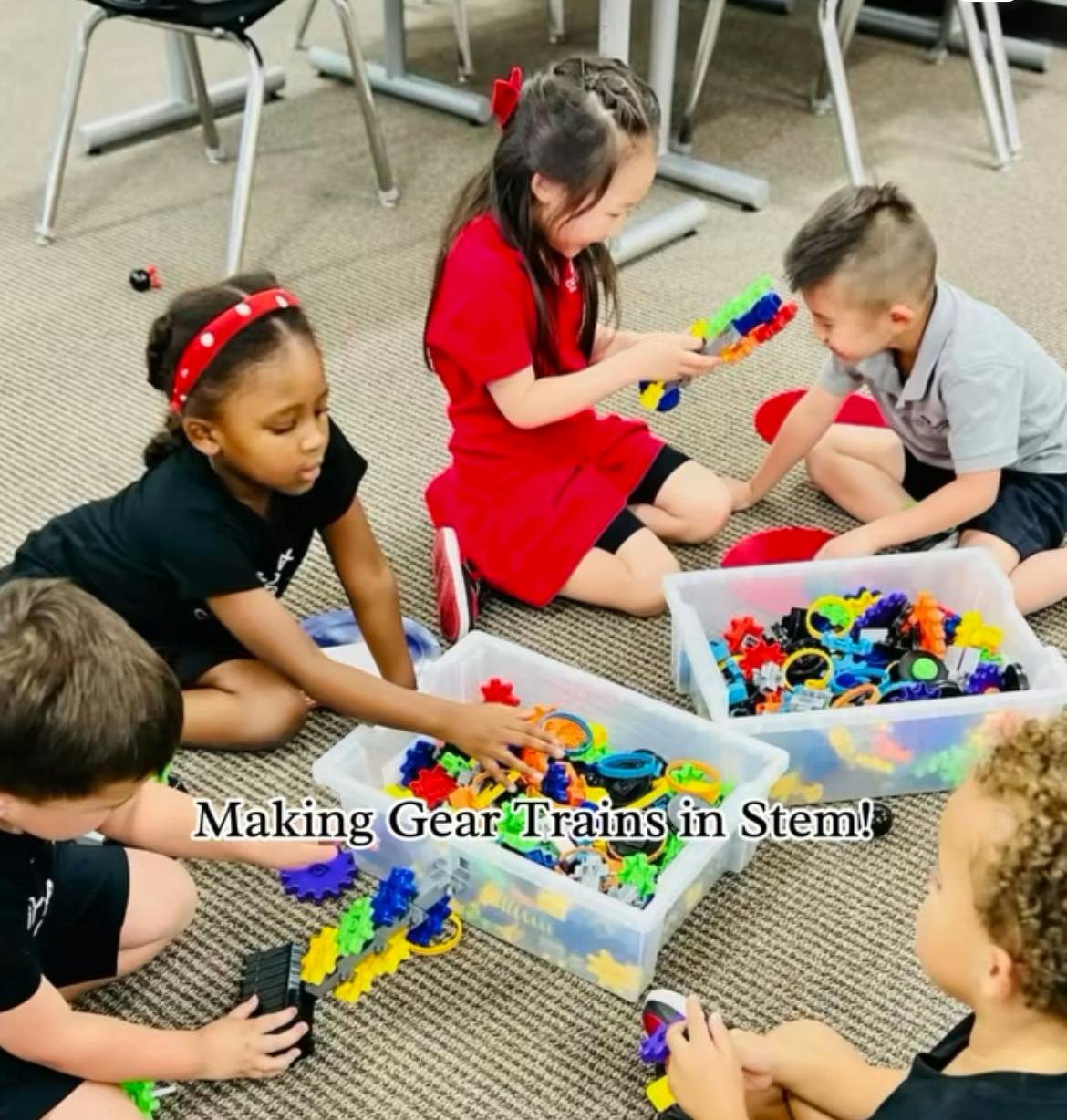 Children playing with colorful interlocking gears on the floor