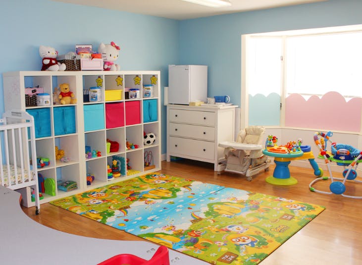 Playroom with toy shelves, changing table, and play mat