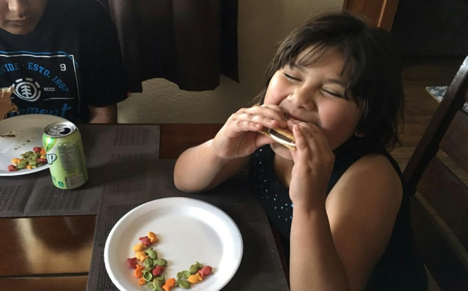 Child eating a sandwich at a table