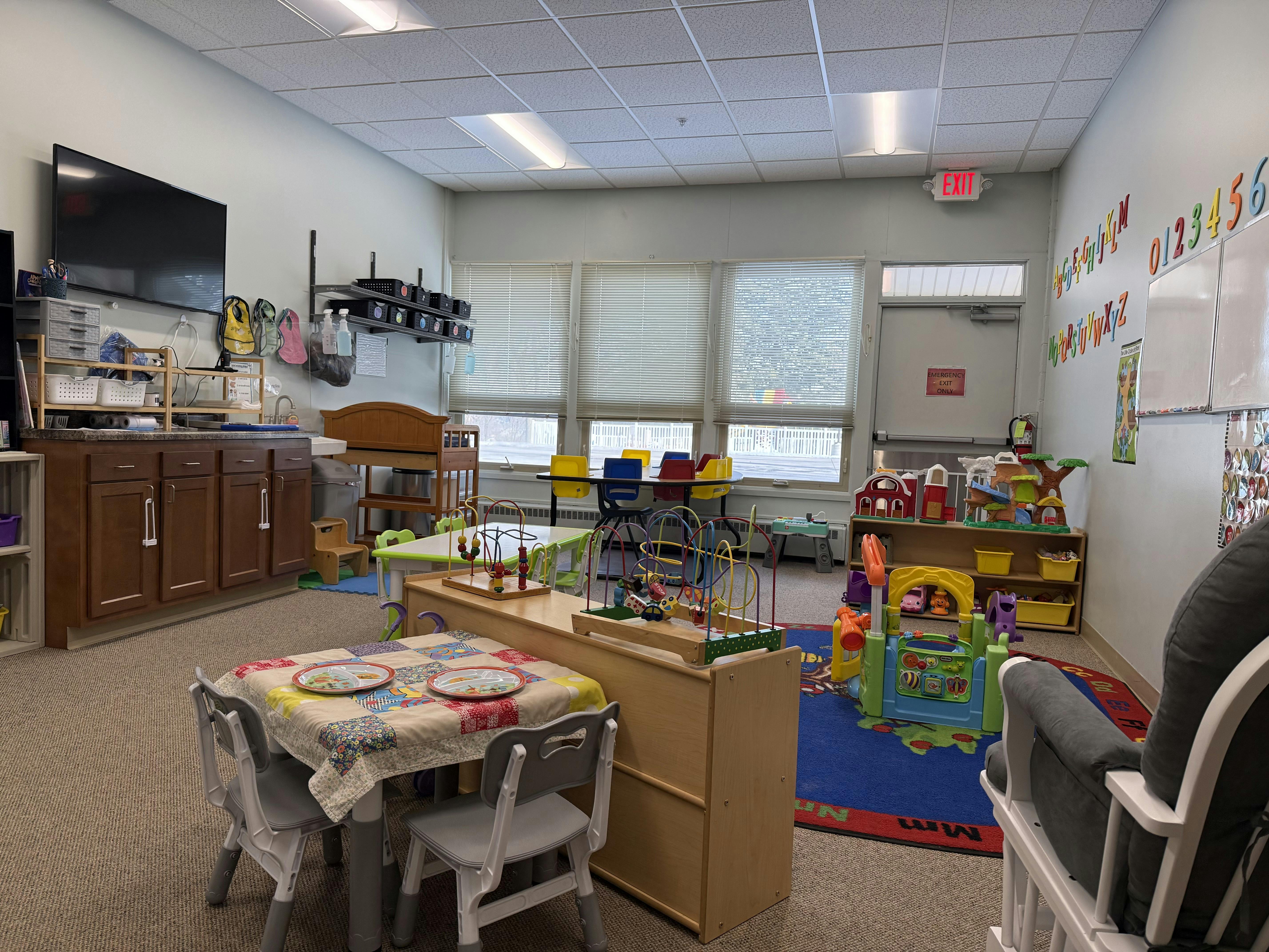 A colorful daycare classroom with various toys, small tables, and chairs