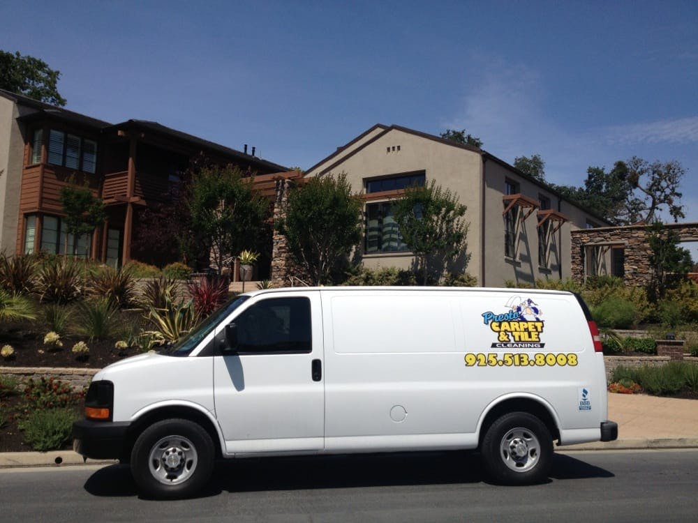 White van with "Carpet Care" logo and phone number parked on street