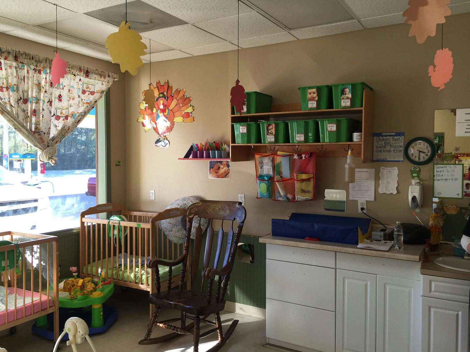 Nursery room with cribs, a rocking chair, and shelves