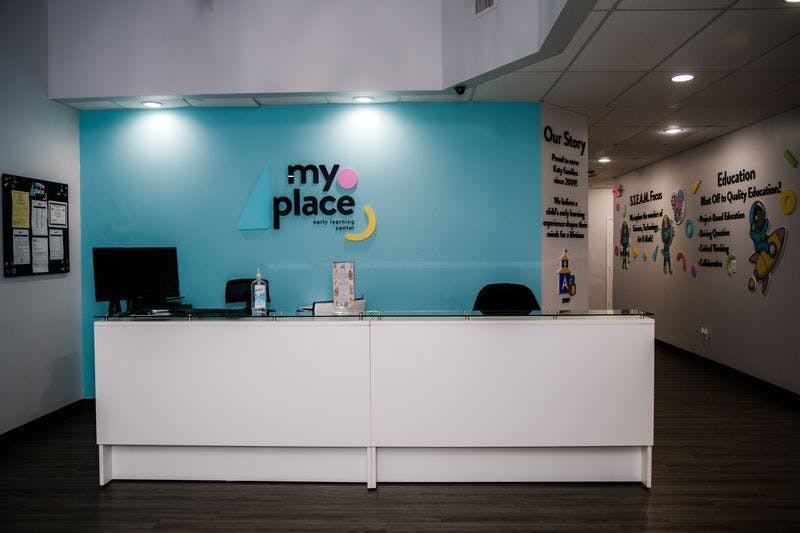 Reception desk with "my place" logo on a blue wall