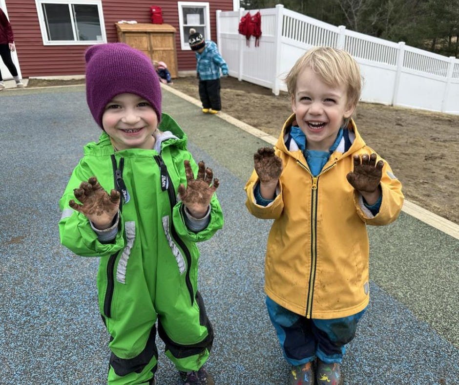 Two children showing their muddy hands