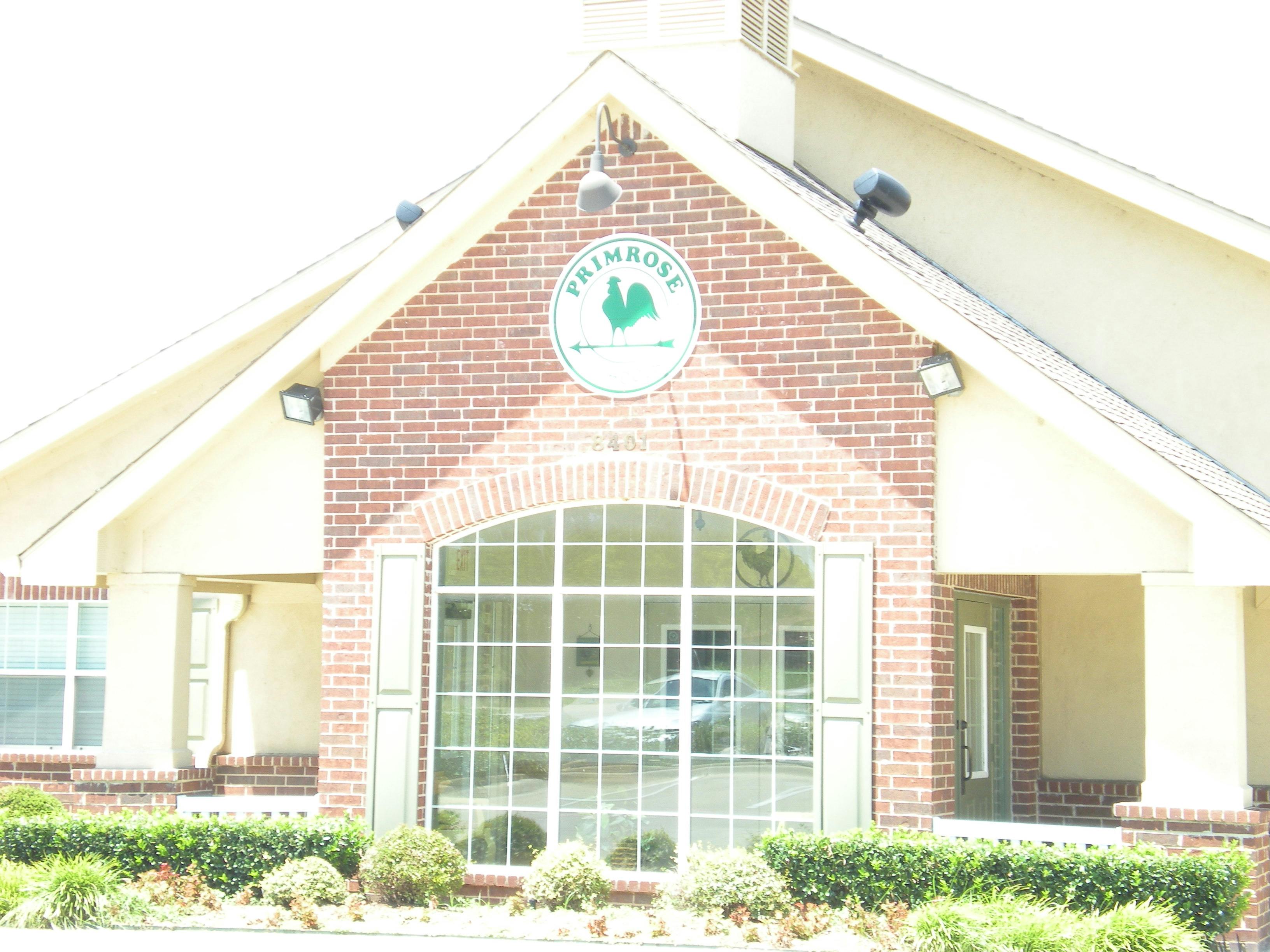 Building exterior with a sign that reads "Primrose" and a rooster logo