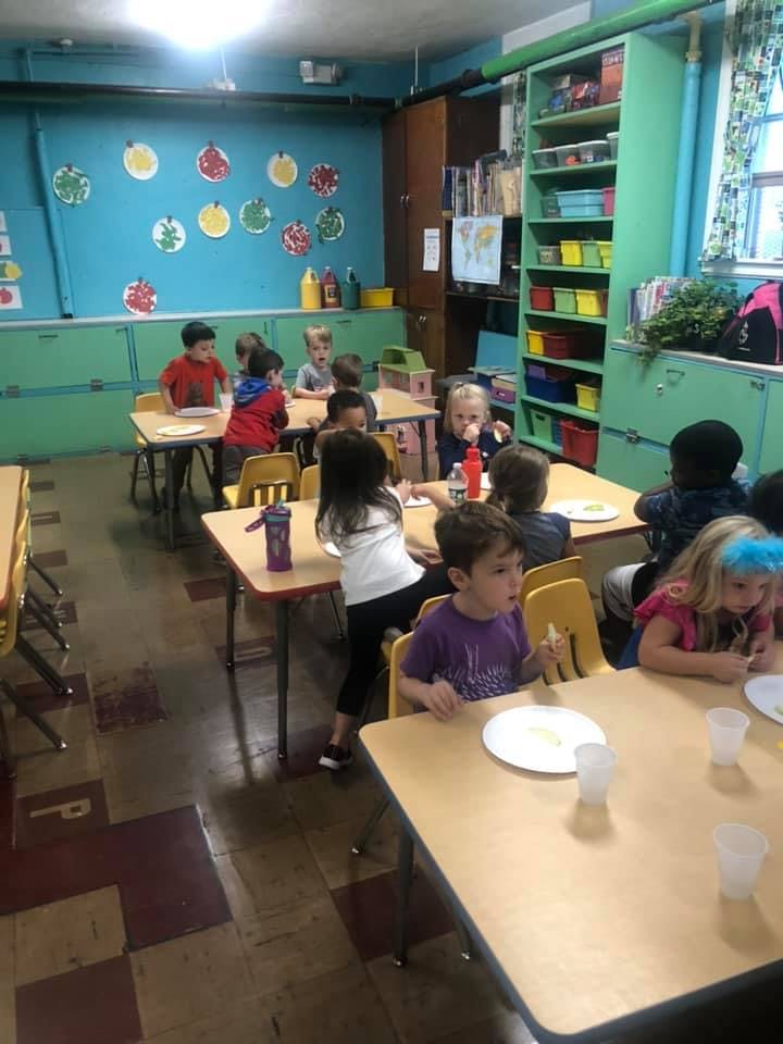 Children sitting at tables in a classroom