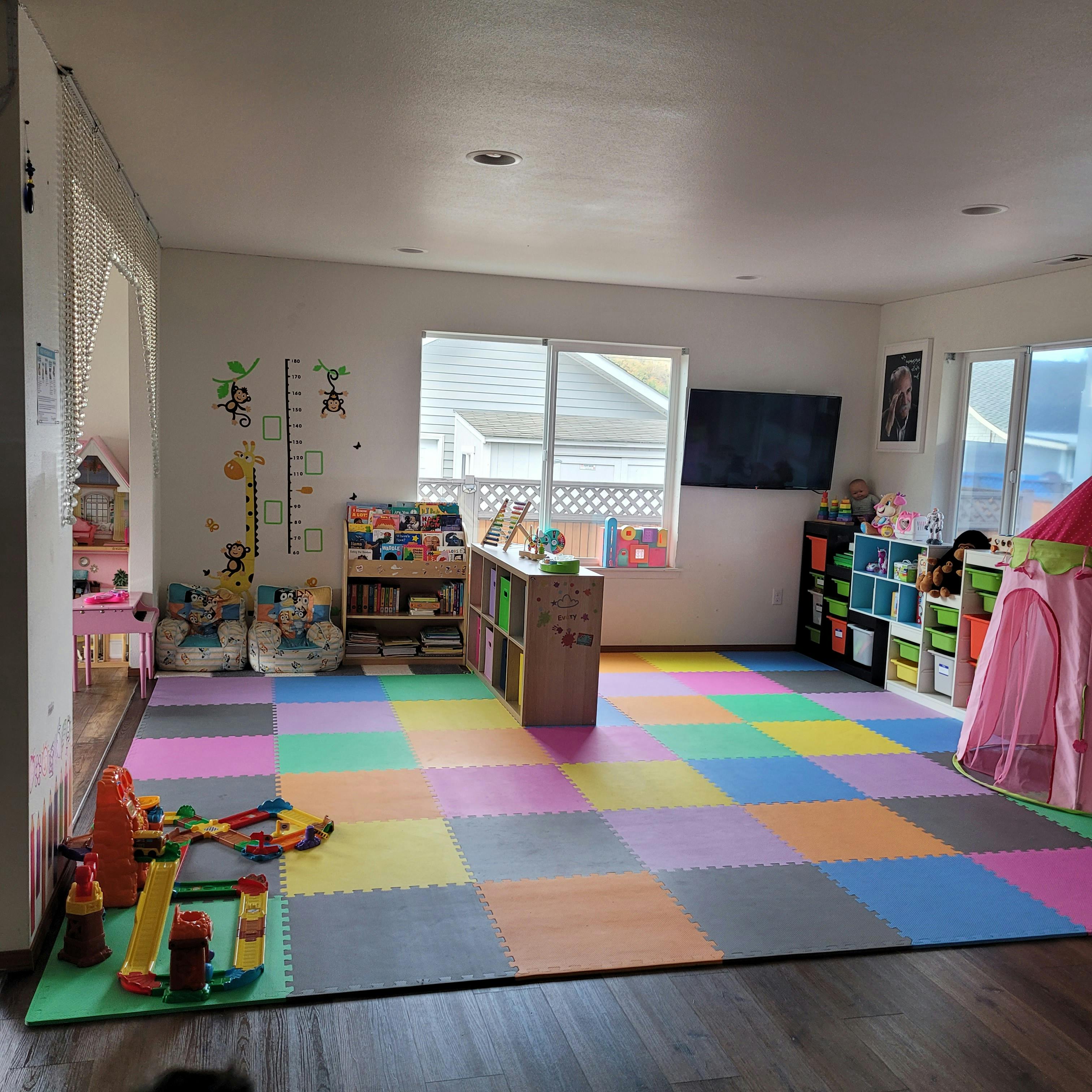 Playroom with colorful foam floor tiles and various toys