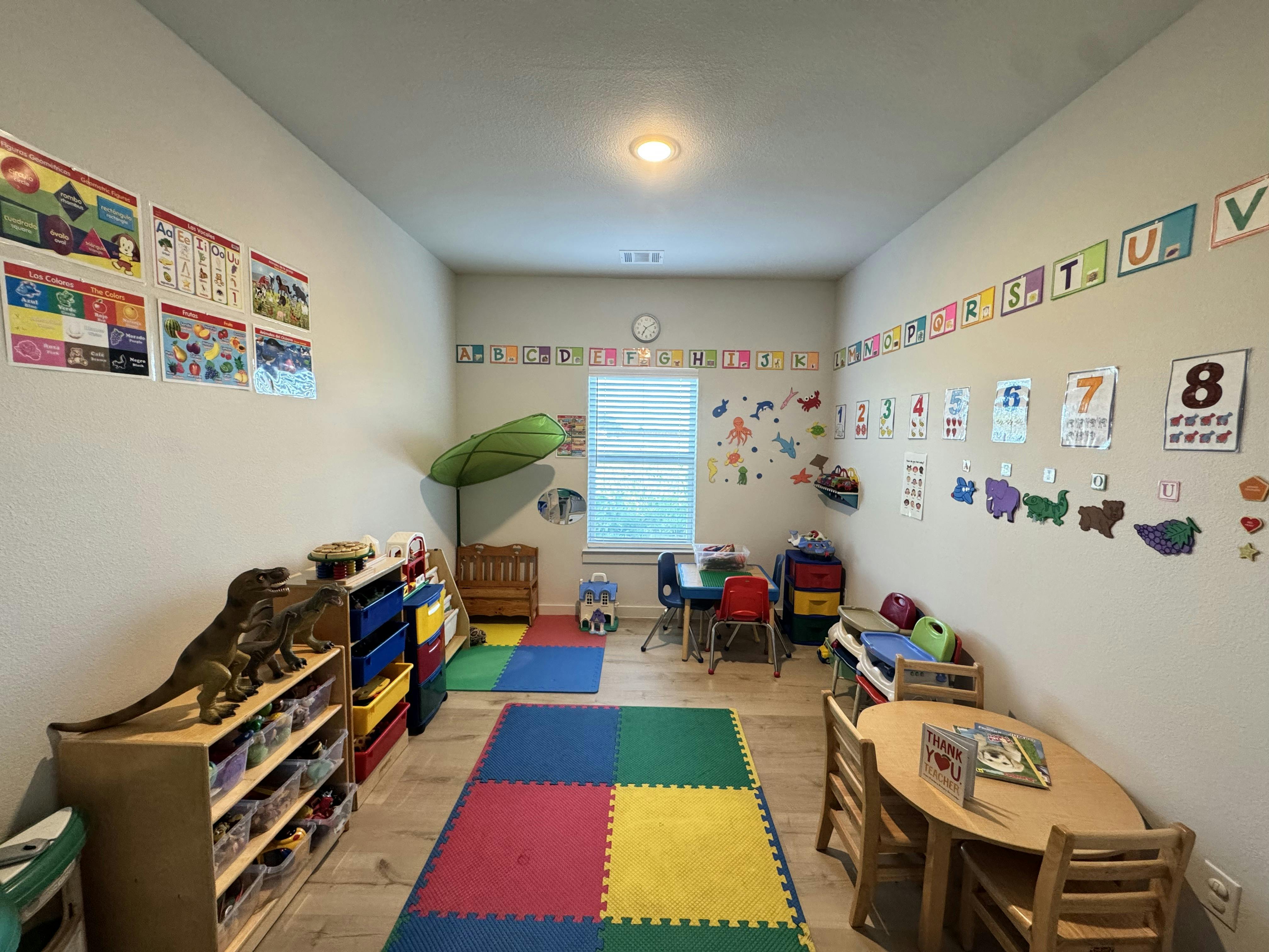 A colorful children's playroom with educational posters and small furniture