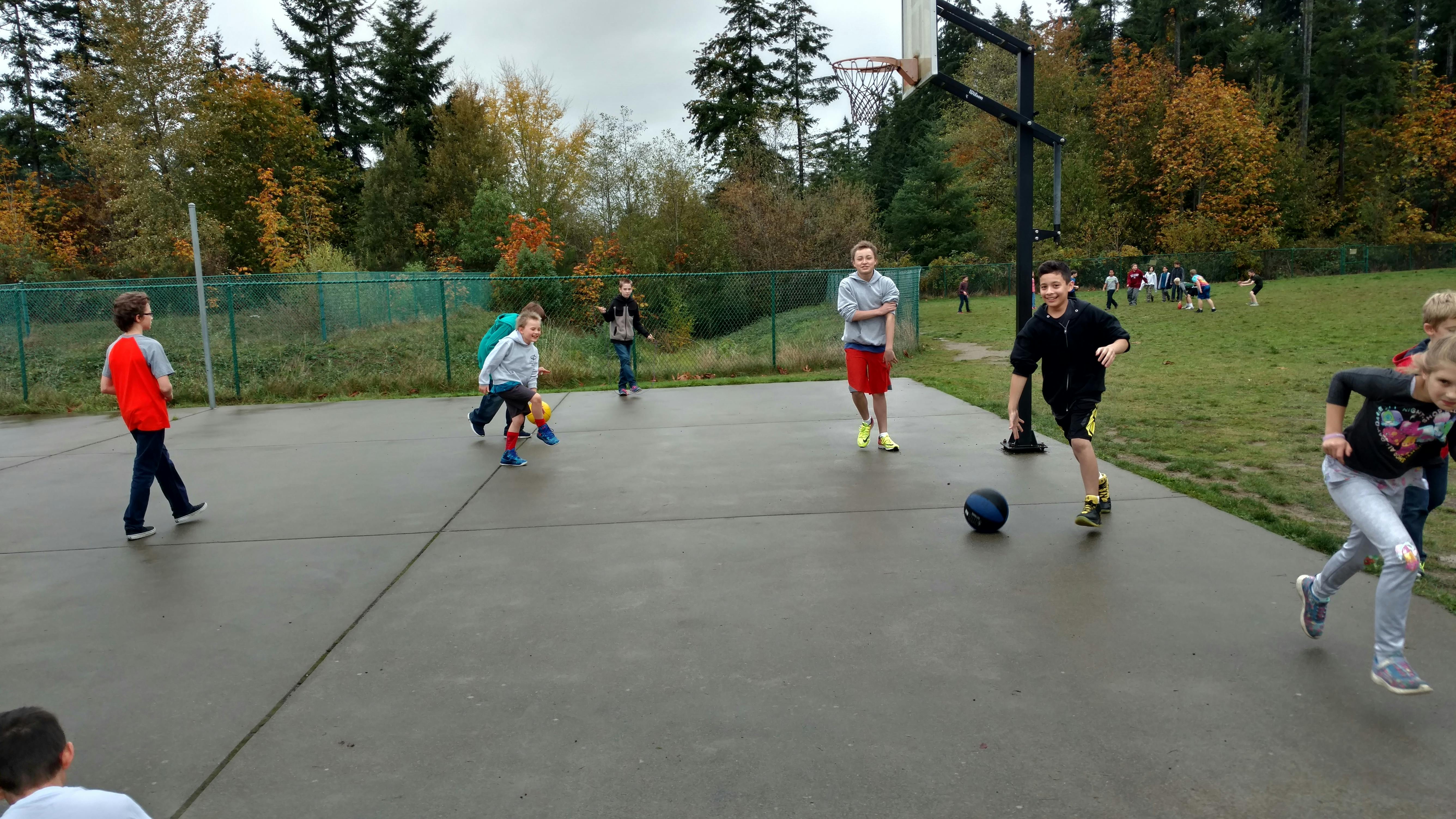 Children playing basketball on an outdoor court