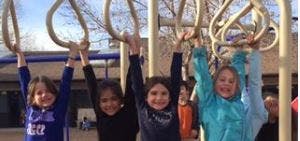 Children hanging from monkey bars