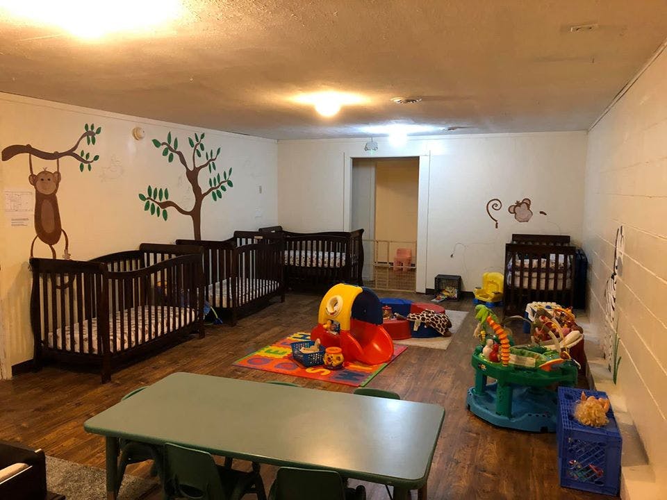 Nursery room with multiple cribs and children's play items