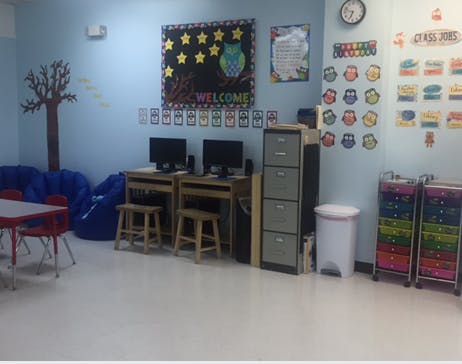 Classroom with computers, tables, and wall decorations