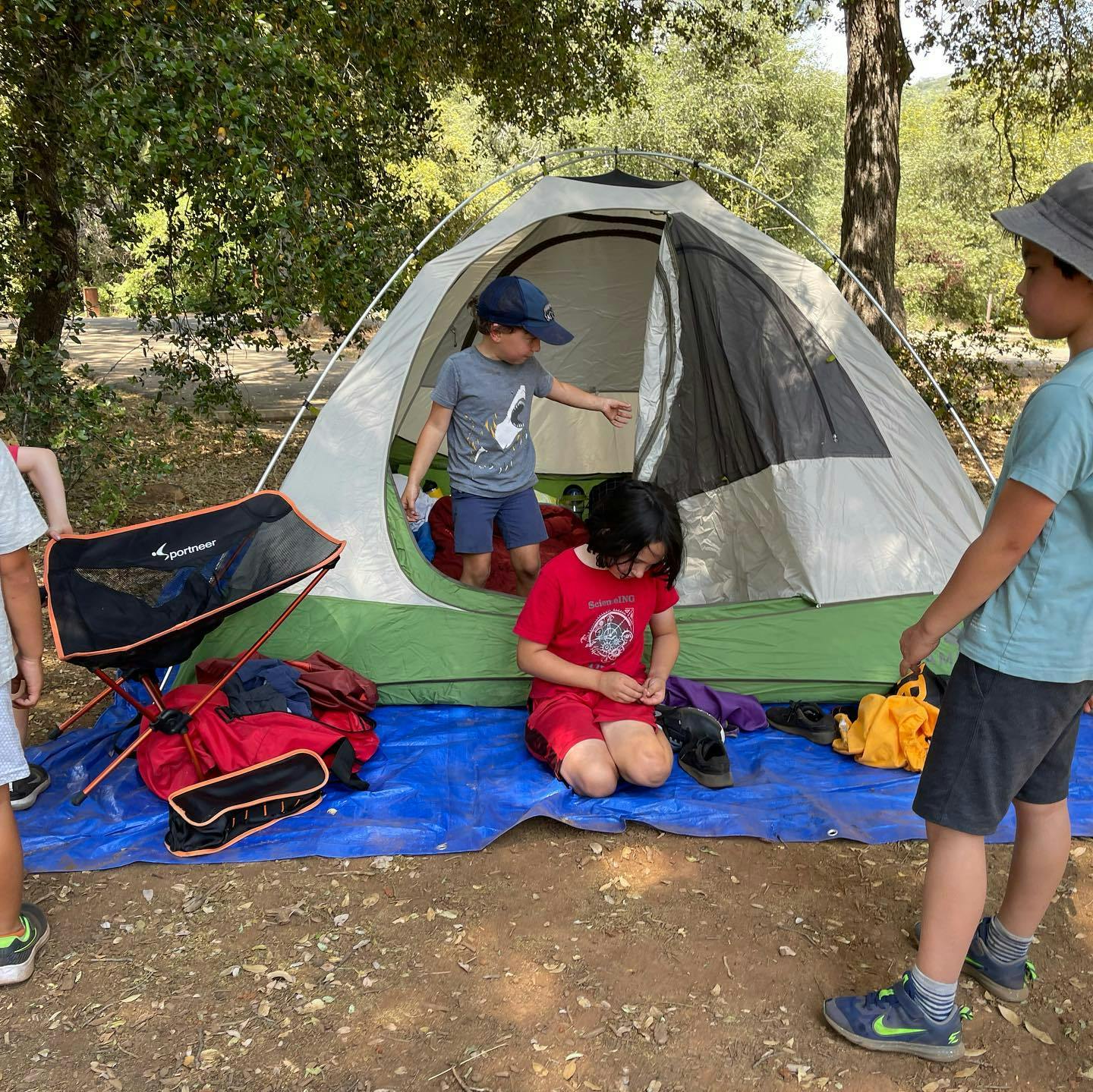 Children around a tent at a campsite
