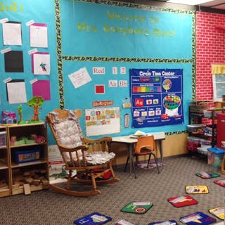 Classroom with a rocking chair, small table, and colorful wall decorations