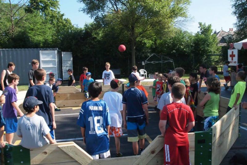 Group of children playing with a red ball outdoors