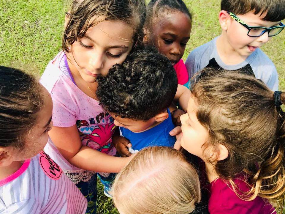 Group of children gathered closely together looking down