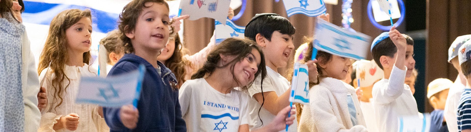 Children holding Israeli flags and waving them