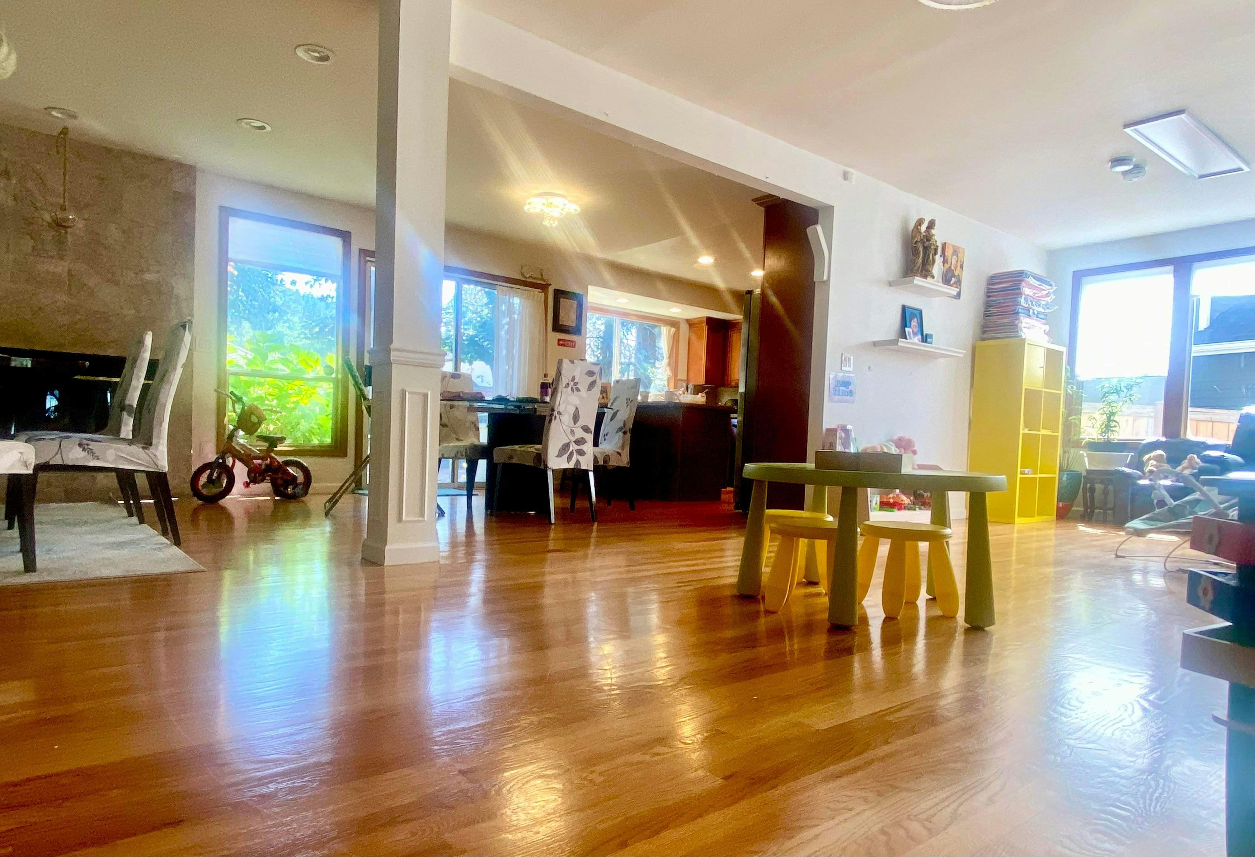 Hardwood floor in a room with a small table and chairs