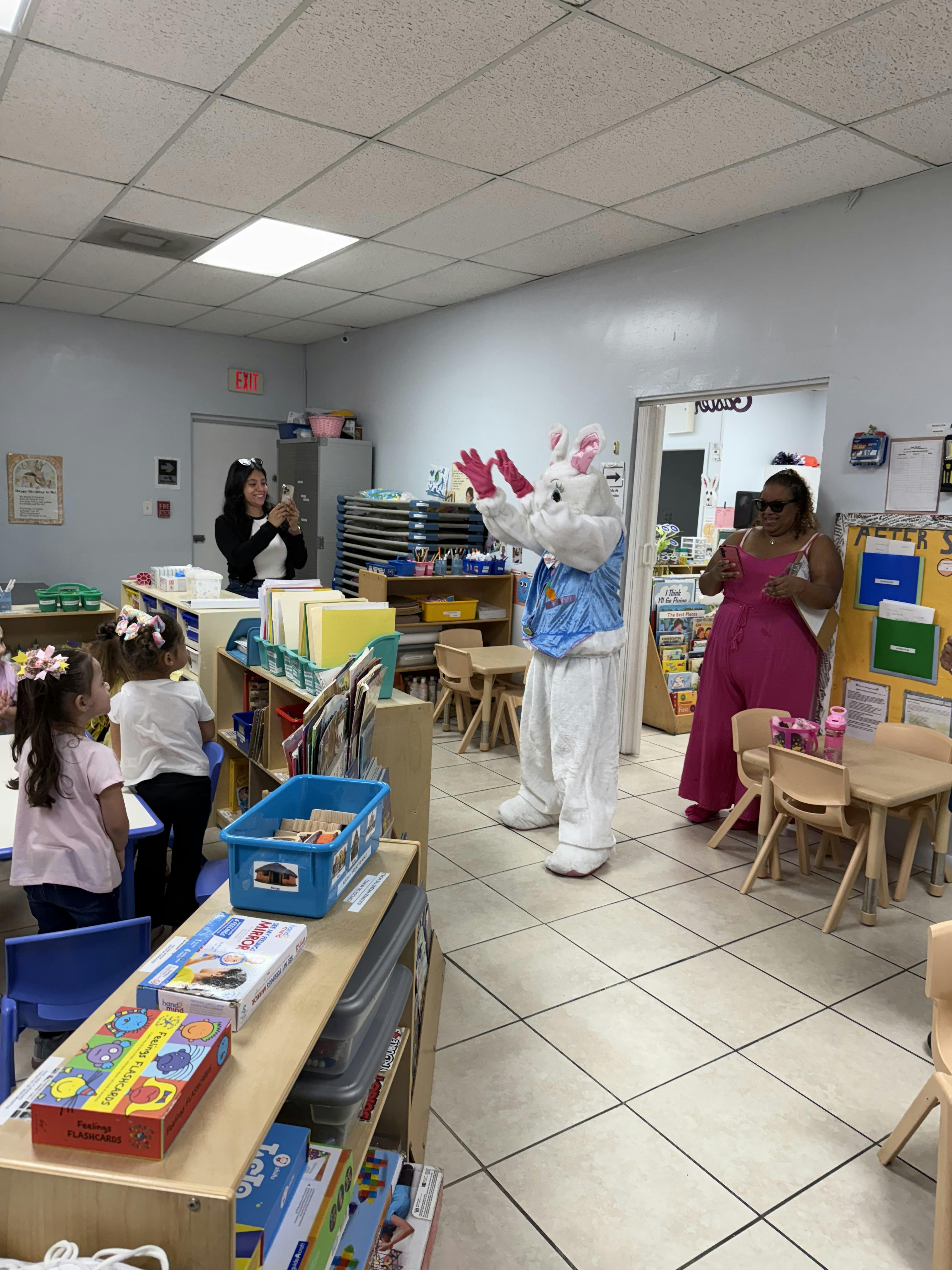 Person in bunny costume with children in a classroom