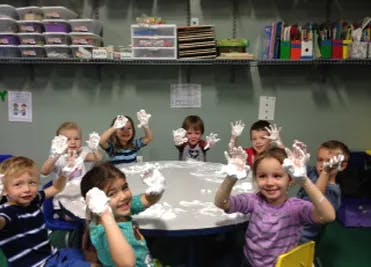 Children with shaving cream on their hands in a classroom
