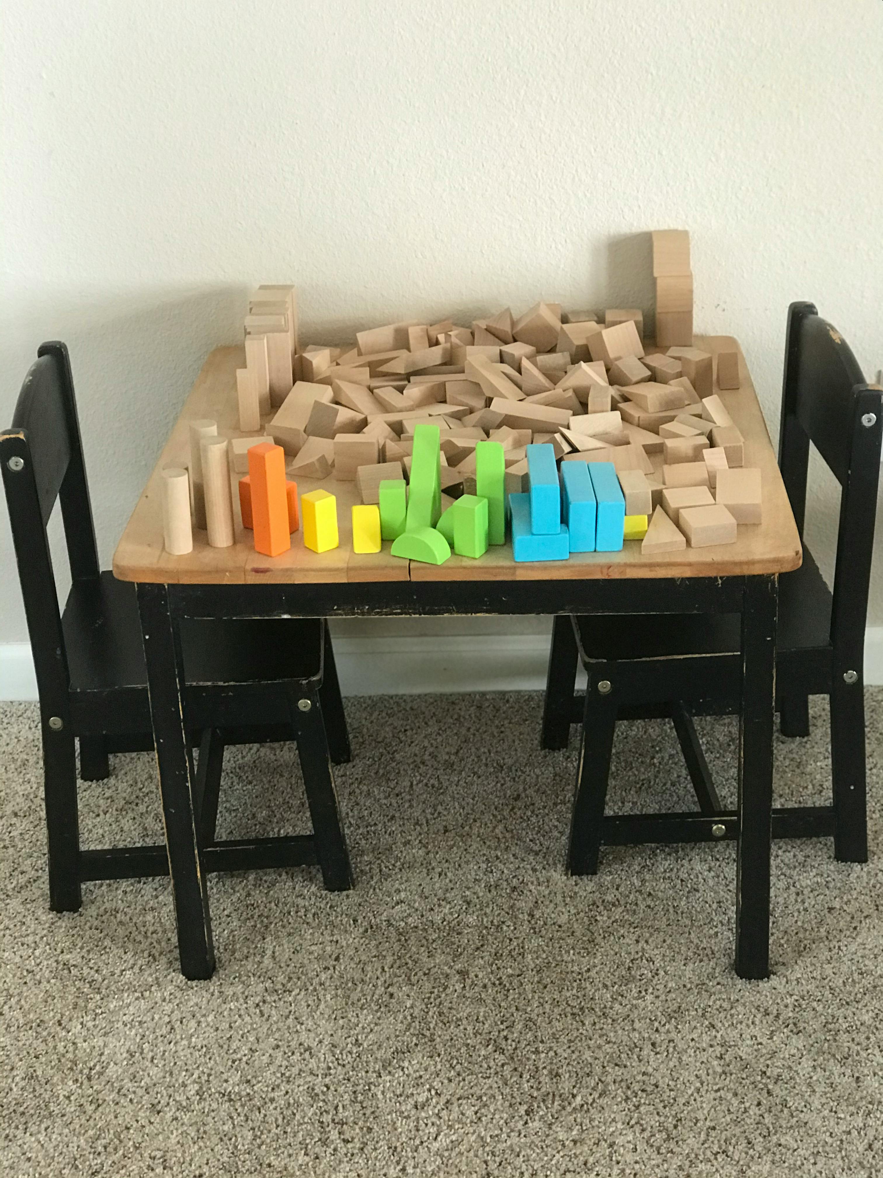Table with wooden building blocks, some colored