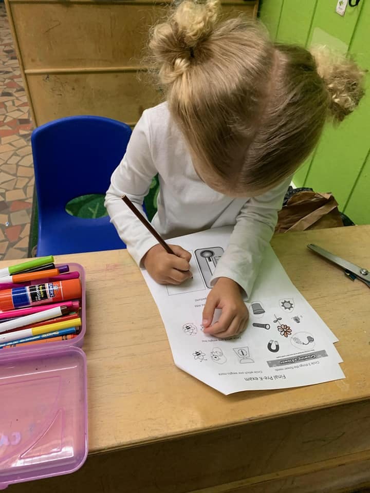 Child drawing on paper at a desk