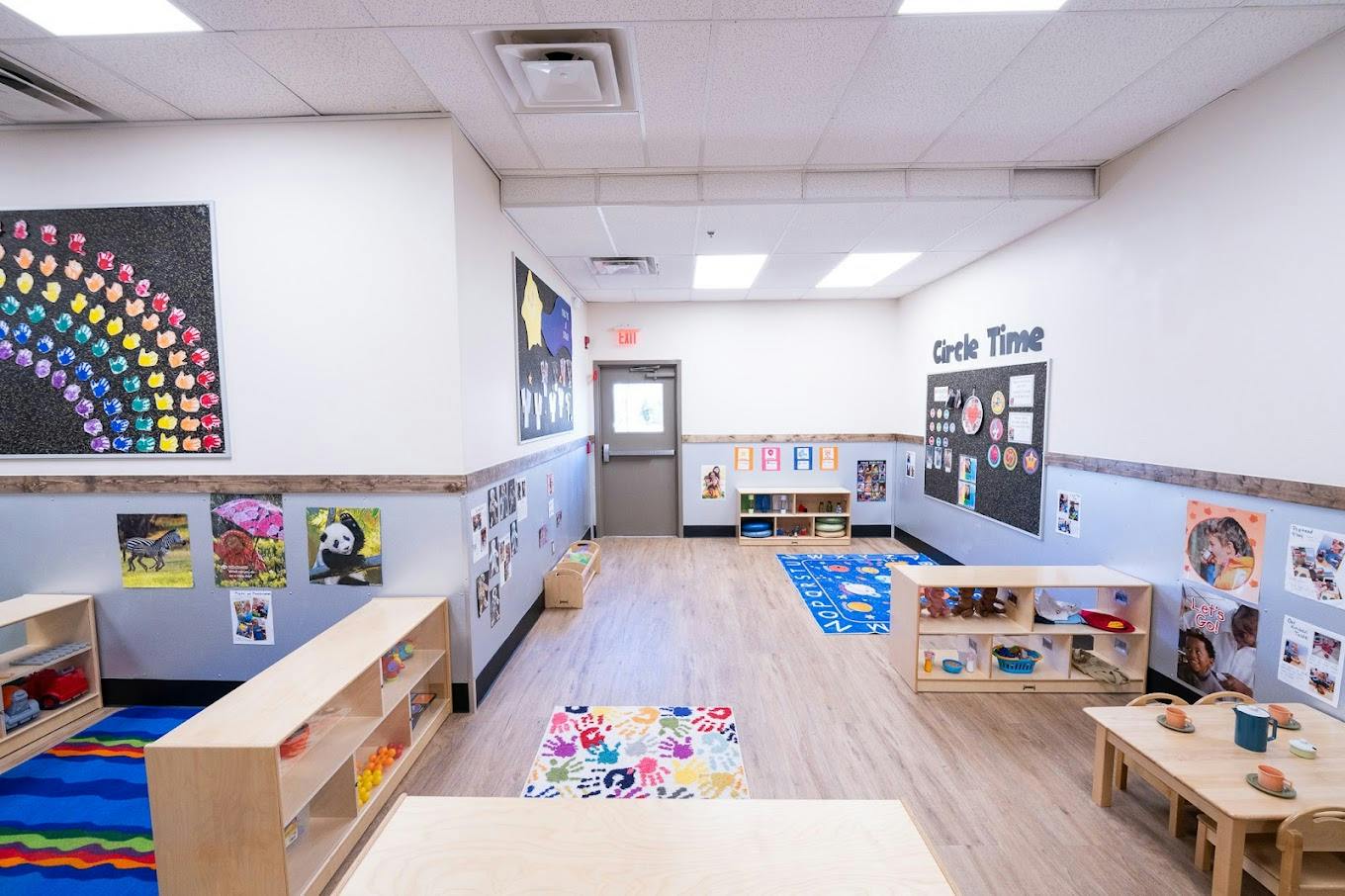Empty preschool classroom with shelves, rugs, and posters