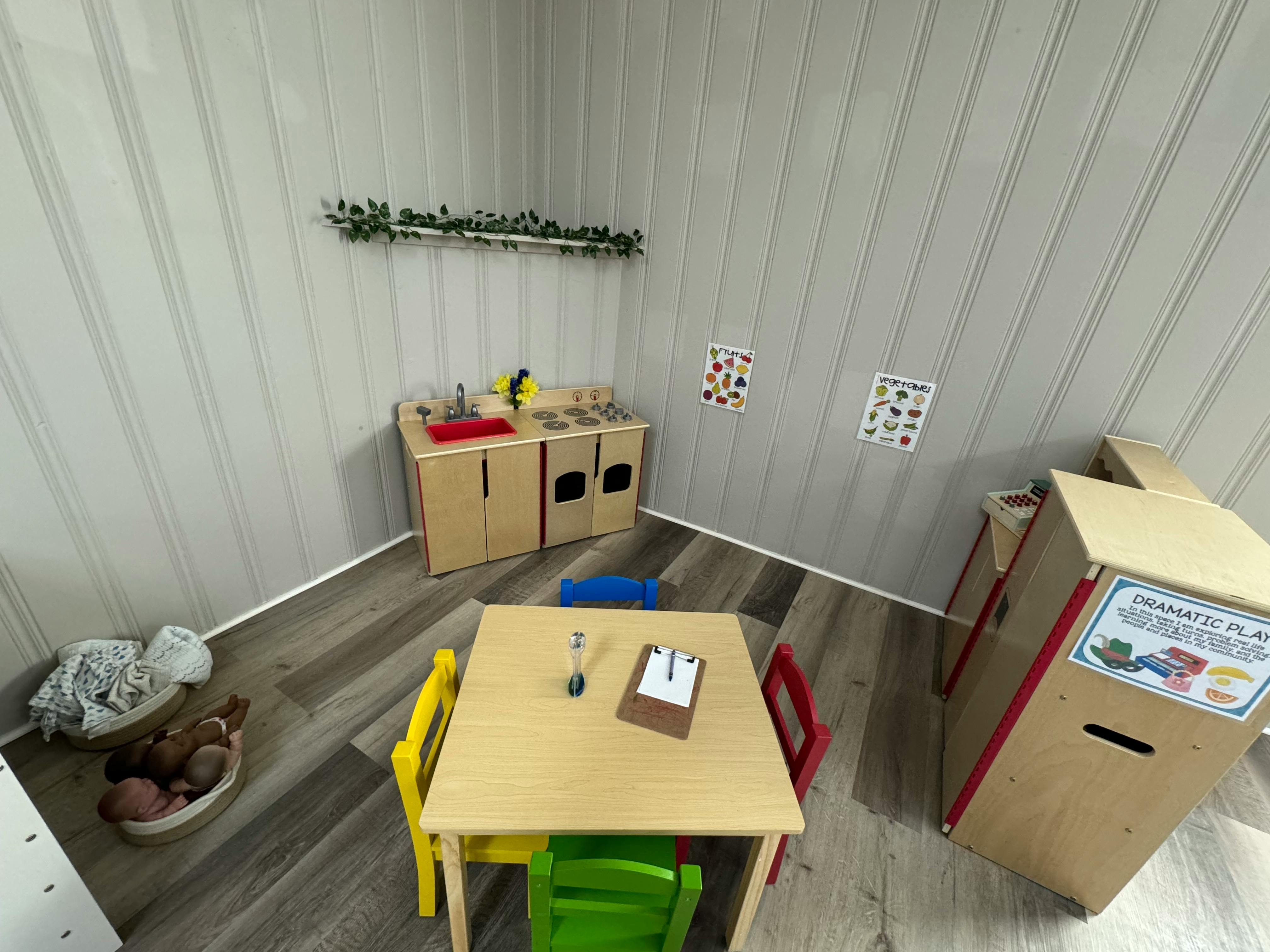 Playroom with small table and chairs, toy kitchen, and other play furniture